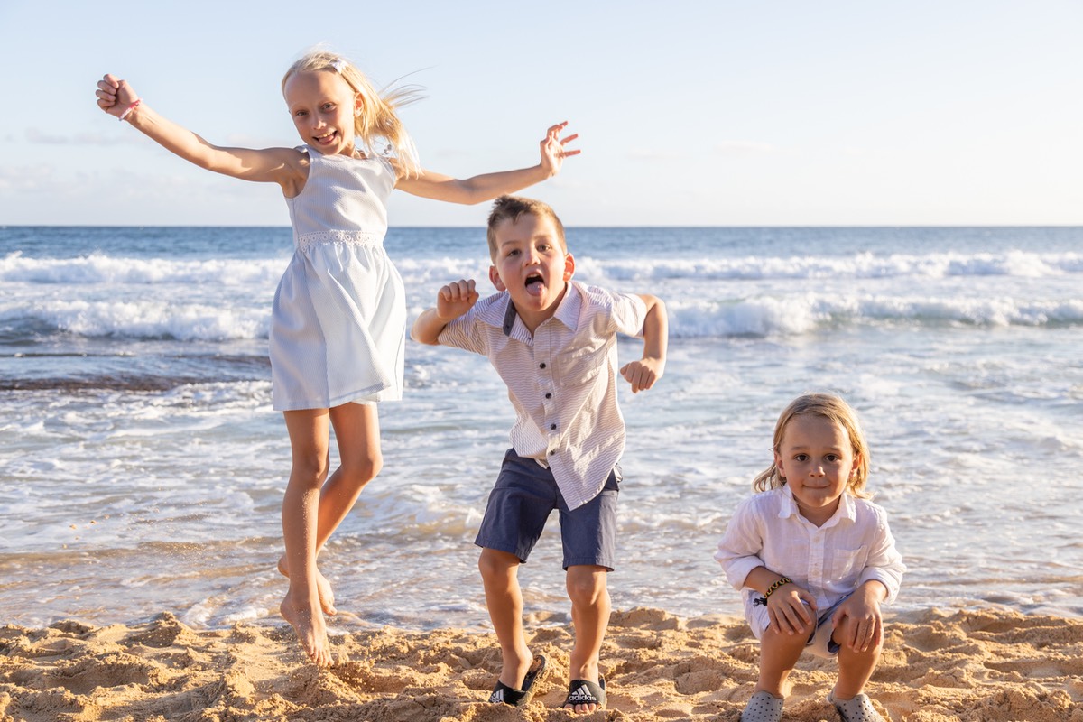3N8A7239 trio of children jumping at the beach in Kauai